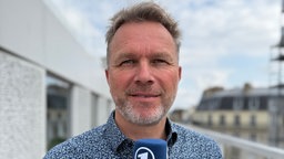 ARD-Korrespondent in Paris: Cai Rienäcker spricht ins ARD-Mikro