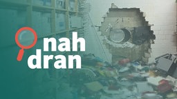 Das Bild zeigt den Tatort. Die Täter haben ein großes Loch in die Wand gebohrt. Viele Gegenstände liegen auf dem Boden. Im Vordergrund steht das Logo von "nah dran". 