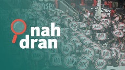 Das Bild zeigt Fans im Stadion, die alle ein Protestschild gegen die Innenministerkonferenz hochhalten, darüber das Logo des Podcasts nah dran. 