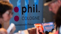 Personen durchstöbern Bücher auf der phil.COLOGNE 2026.