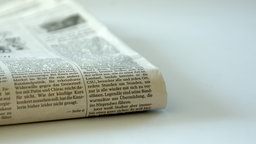 Zeitung liegt gefalten auf einem Tisch