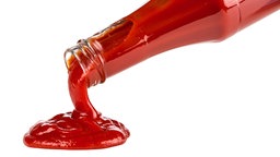 Aus einer gekippten Ketchup-Flasche läuft Ketchup