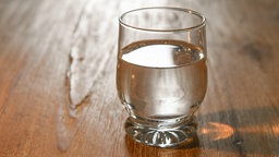 Ein Wasserglas auf einem Holztisch