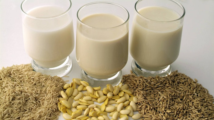 Drei Gläser mit Milchalternativen stehen vor einem weißen Hintergrund