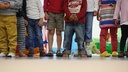 Symbolbild: Beine und Füße unterschiedlicr Kinder, barfuß und mit Schuhen