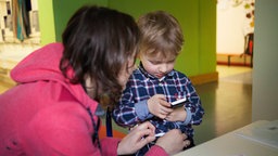 Symbolbild Alltagsbegleitung für Kinder: Eine Frau begleitet einen kleinen Jungen.
