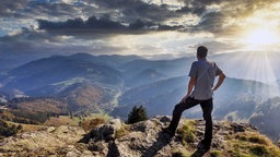 Symbolbild Stille: Ein Wanderer genießt die Aussicht 