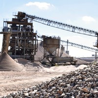Kiesgewinnungsanlage mit Kieshaufen im Vordergrund