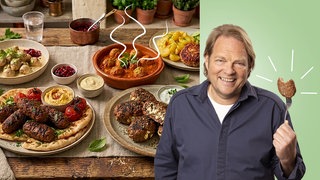 Björn Freitag und im Hintergrund verschiedene Arten von Frikadellen.