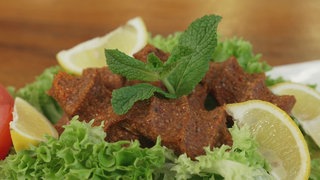 Giköpfte serviert mit Salat, Zitrone und Minze.