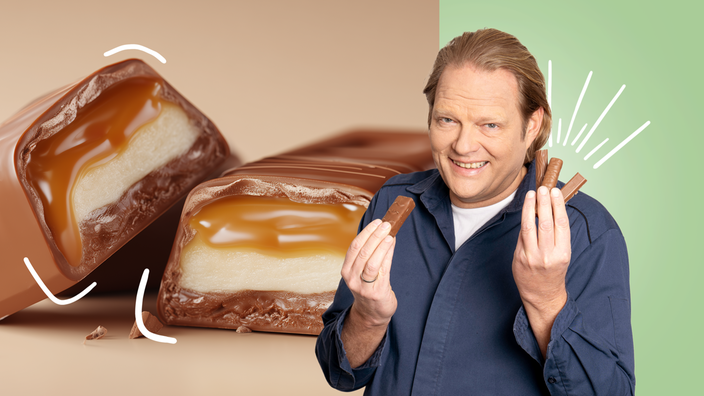 Das Bild zeigt Björn Freitag mit mehreren Schokoriegeln in der Hand. 