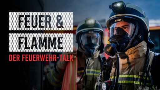 Zwei Feuerwehrleute vor einem Feuerwehrfahrzeug