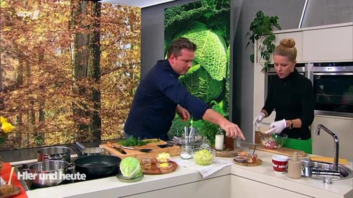 Koch Fabian Timmer und Moderatorin Miriam Lange stehen an der Küchenzeile im Hier und Heute Studio