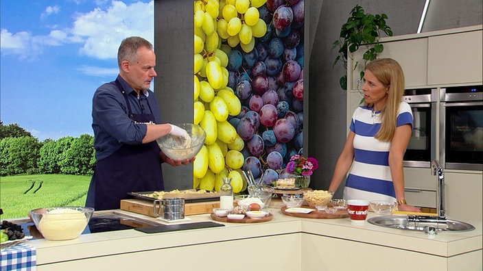 Marcel Seeger und Miriam Lange bereiten Trauben-Streuselkuchen zu.