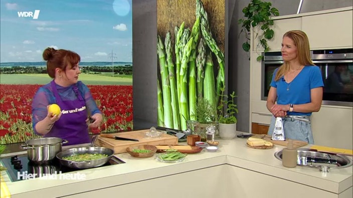 Julia Floß steht mit Moderatorin Miriam Lange an der Küchenzeile im Hier und Heute Stduio während sie kochen