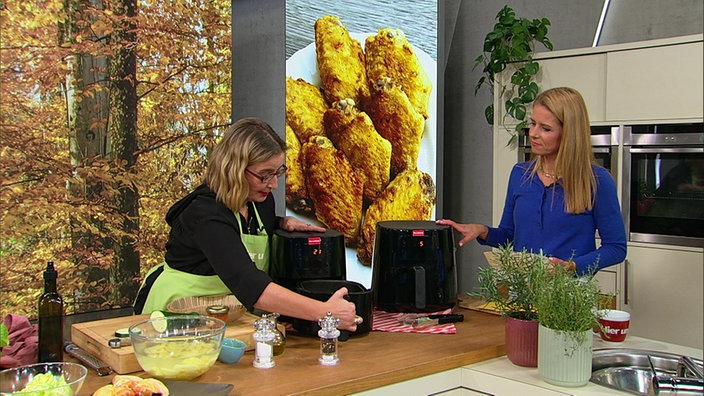 Yvonne Willicks und Miriam Lange bereiten Airfryer Pommes und Chicken Wings zu