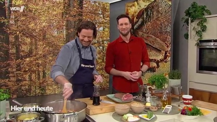 Olaf Baumeister und Sven Kroll stehen gemeinsam hinter einem Herd