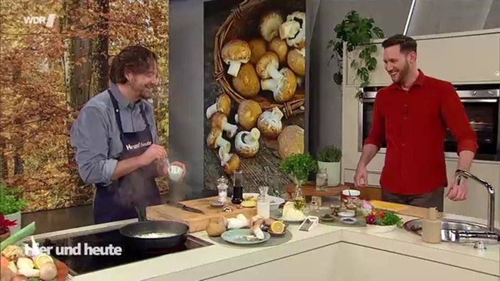 Olaf Baumeister und Sven Kroll stehen gemeinsam hinter einem Herd