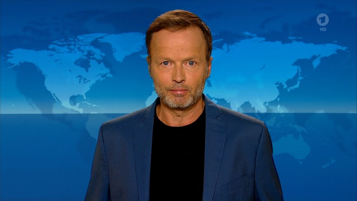 Der Tagesthemen-Kommentar von Georg Restle blickt in die Kamera vor dem Hintergrund des Tagesthemen-Studios.