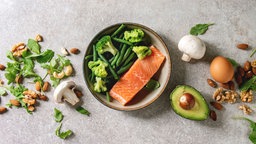 Das Bild zeigt Lachs, Nüsse und Avocado.