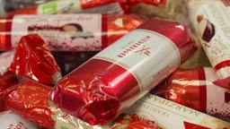 Das Bild zeigt die verschiedenen Marzipanbrote in roten Verpackugen, die getestet werden.
