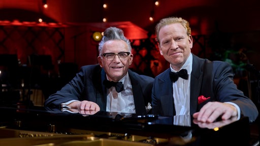 Daniel Hope und Götz Alsmann sitzen anlässlich der Jubiläumsshow an einem Flügel in der Essener Philharmonie