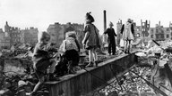 Kinder spielen in Trümmerhaufen