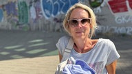 Frau mit Sonnenbrille schaut in die Kamera