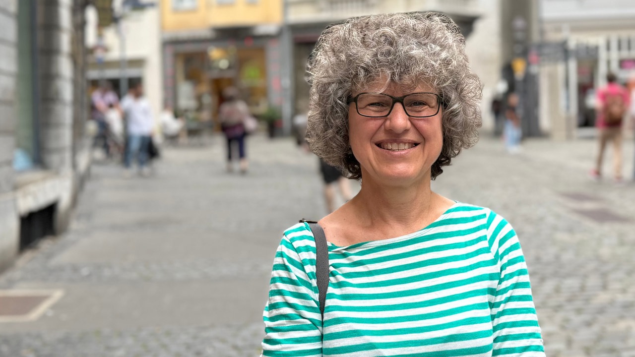 Frau mit grauen Locken schaut in die Kamera