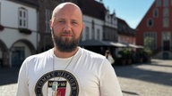 Junger Mann schaut in die Kamera