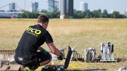 Abschussvorrichtungen für das Feuerwerk der Rheinkirmes werden von einem Mann vorbereitet