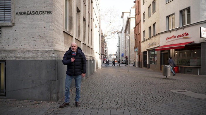 WDR-Moderator Andreas Bursche steht vor dem Andreaskloster in Köln.