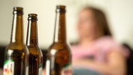 Bierflaschen, im Hintergrund verschwommen eine Frau