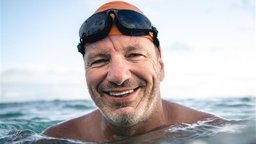 Extremschwimmer und Meeresbotschafter André Wiersig mit Taucherbrille im Wasser