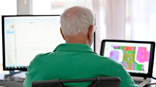 Ein Senior arbeitet in seiner Elektronik-Werkstatt im Home-Office