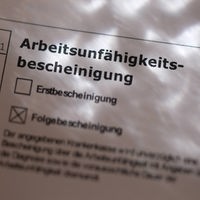 Eine Arbeitsunfähigkeitsbescheinigung vom Hausarzt mit dem Kreuz bei Folgebescheinigung 