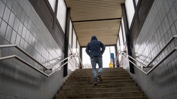 Ein Mann geht Stufen an einem Bahnhof hoch 