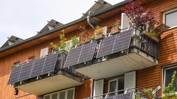 Solarkraftwerke für sogenannte Balkonkraftwerke hängen an einem Balkon