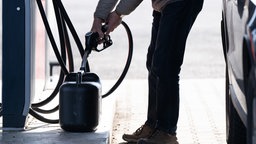 Sprit wird an einer Tankstelle in einen Reservekanister gefüllt