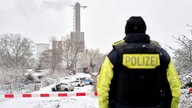 Ein Polizeibeamter steht an der Brandstelle in Berlin 