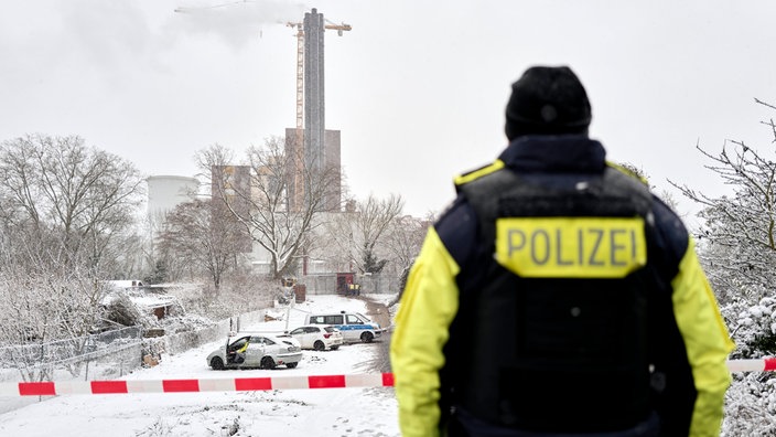 Ein Polizeibeamter steht an der Brandstelle in Berlin 