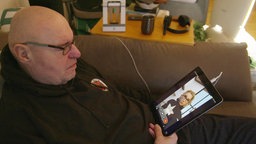 Mann mit einem Tablet auf dem Sofa