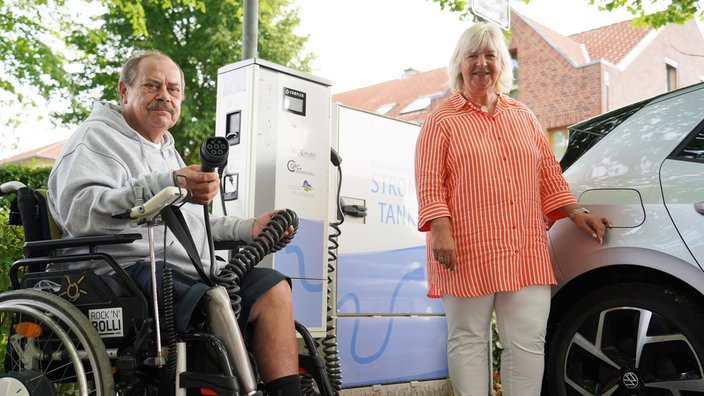 Rüdiger Werner und Bürgermeisterin Marion Dirks testen die neue, barrierefreie Lademöglichkeit.  