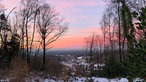 Rot gefärbter Himmel über leicht verschneitem Oerlinghausen
