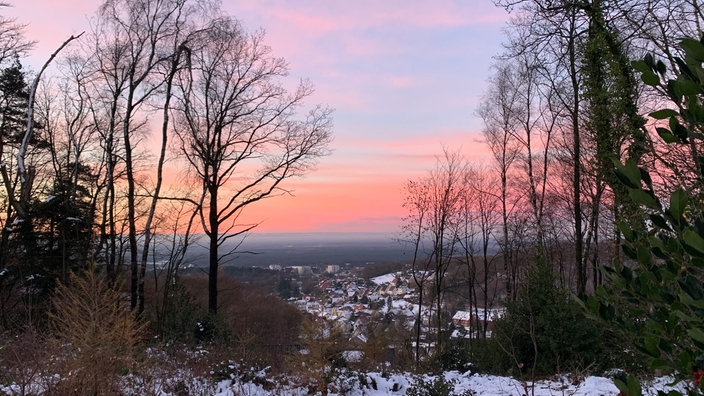 Rot gefärbter Himmel über leicht verschneitem Oerlinghausen