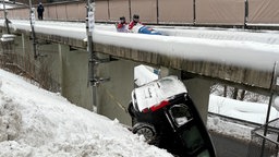 Verunfalltes Auto und Menschen, die Bobbahn fahren in Winterberg 