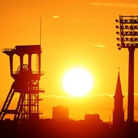 Die Sonne geht über dem Förderturm der Zeche Holland auf.
