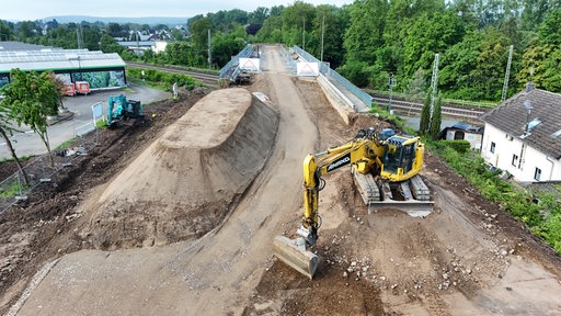 Ein Bagger steht vor einer Brücken-Baustelle.