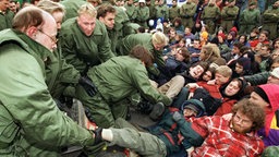 Polizisten räumen am Freitag (20.3.1998) in Ahaus einen von Demonstranten blockierten Bahnübergang.