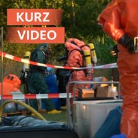 Spezielle Einheit der Feuerwehr in Schutzanzügen betrachtet gefundene Fässer 